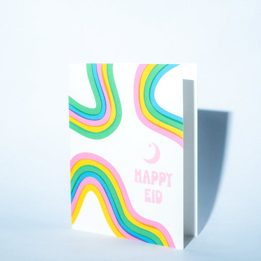 Greeting card with colorful rainbow design and 'Happy Eid' text on a light blue background